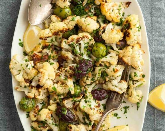 Roasted Cauliflower with Olives on Platter with Lemon Wedges