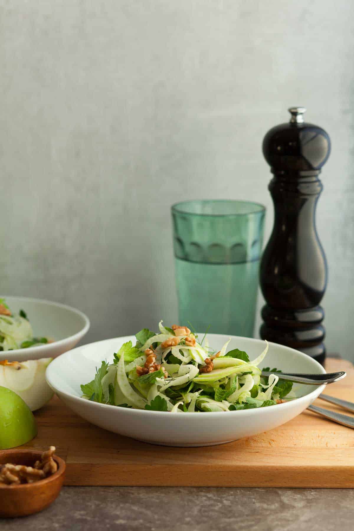 Apple Fennel Salad in Bowl with Fork on Wood Board