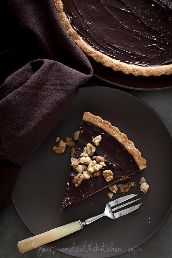 Chocolate Date Caramel Walnut Tart slice on plate