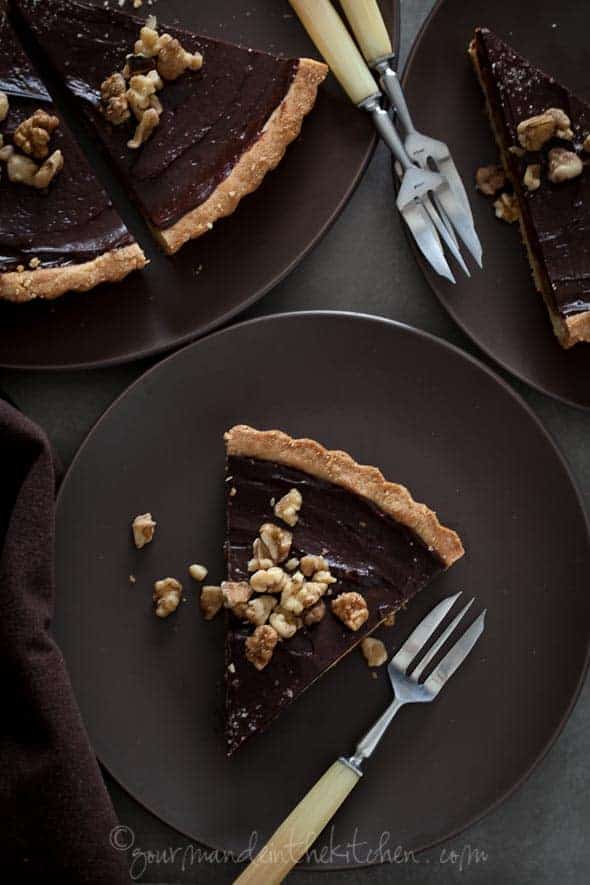 chocolate date walnut tart sliced on plates