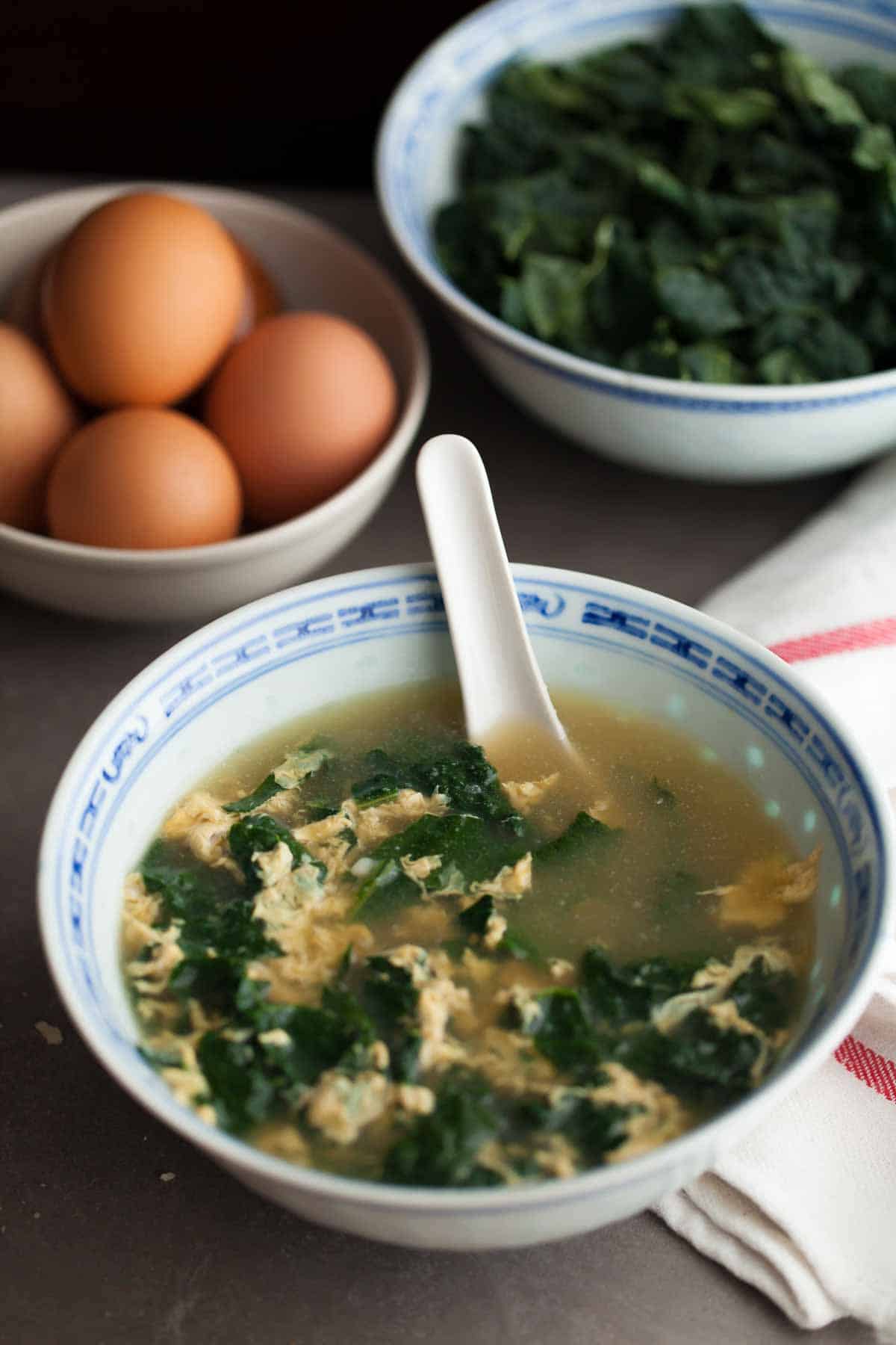 Italian Egg Drop Soup (Stracciatella) on Table with Spoon