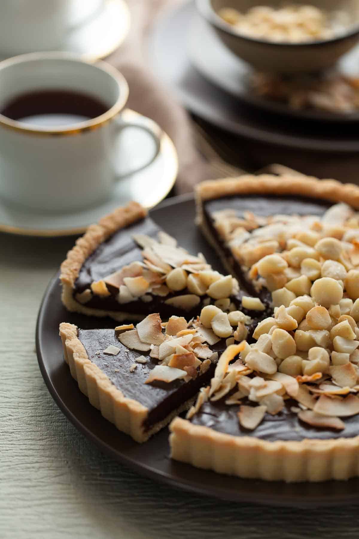 Chocolate Coconut Macadamia Nut Tart on Serving Plate with Coffee Cups and Plates