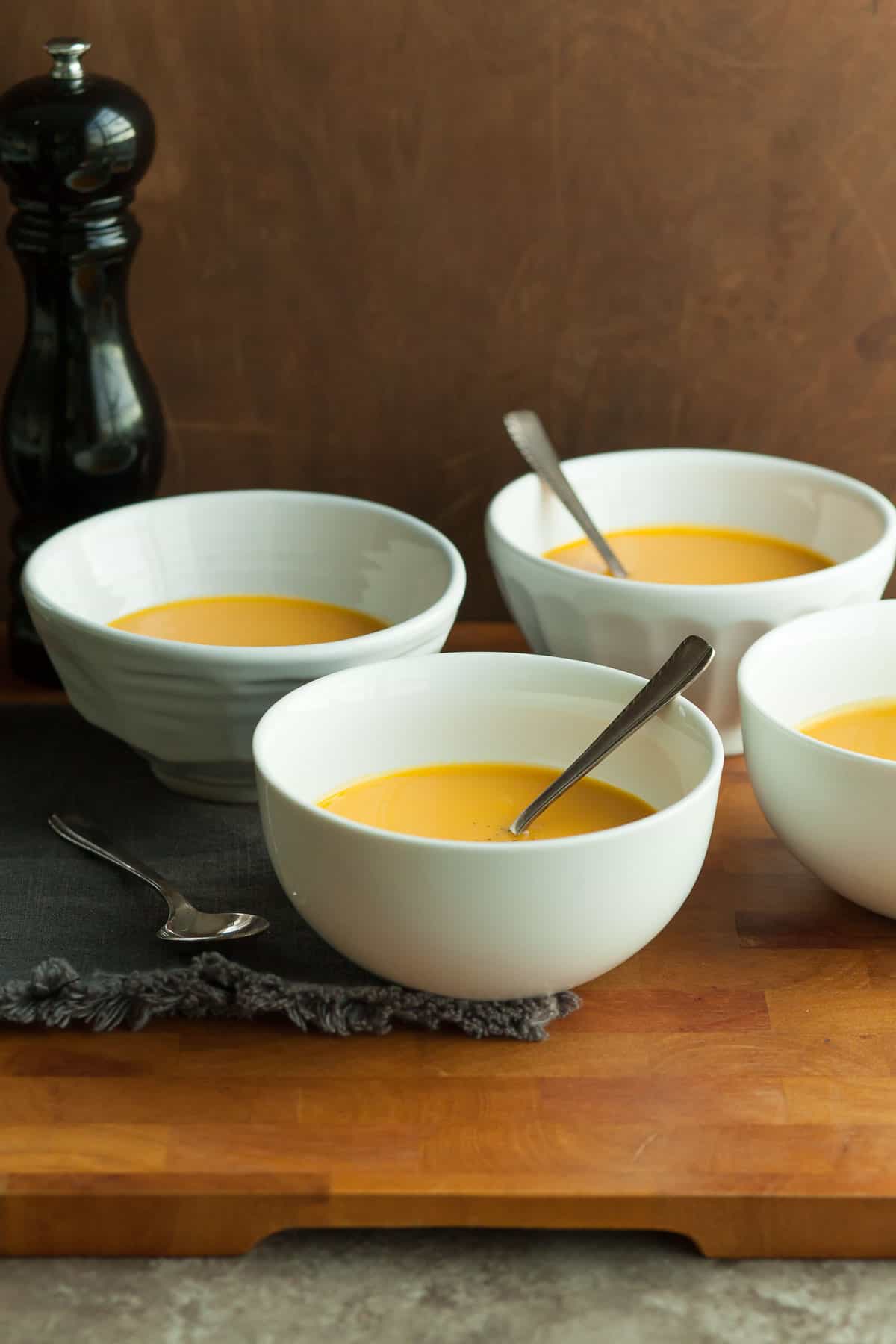 Carrot Ginger Turmeric Soup in bowls on wood board