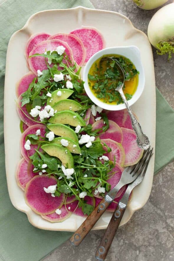 Watermelon Radish Carpaccio with Citrus Avocado Dressing- Watermelon radishes are shaved paper thin and dressed with a citrus avocado vinaigrette.