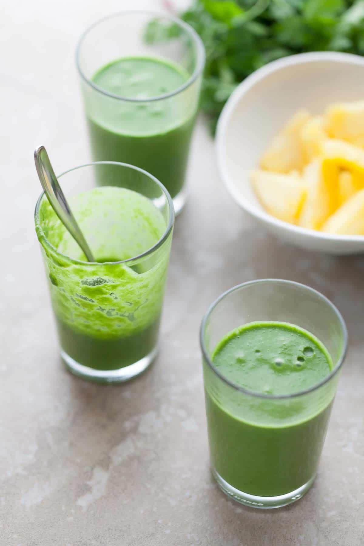 Green smoothies in glasses with spoon