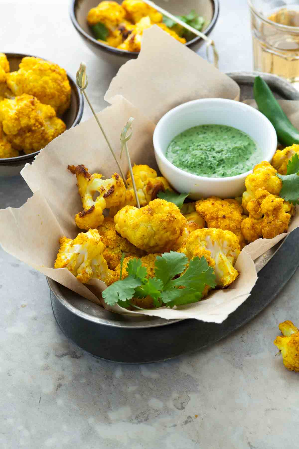 Turmeric roasted cauliflower served with cilantro chutney is an easy appetizer or side dish with lots of bright color and flavor.