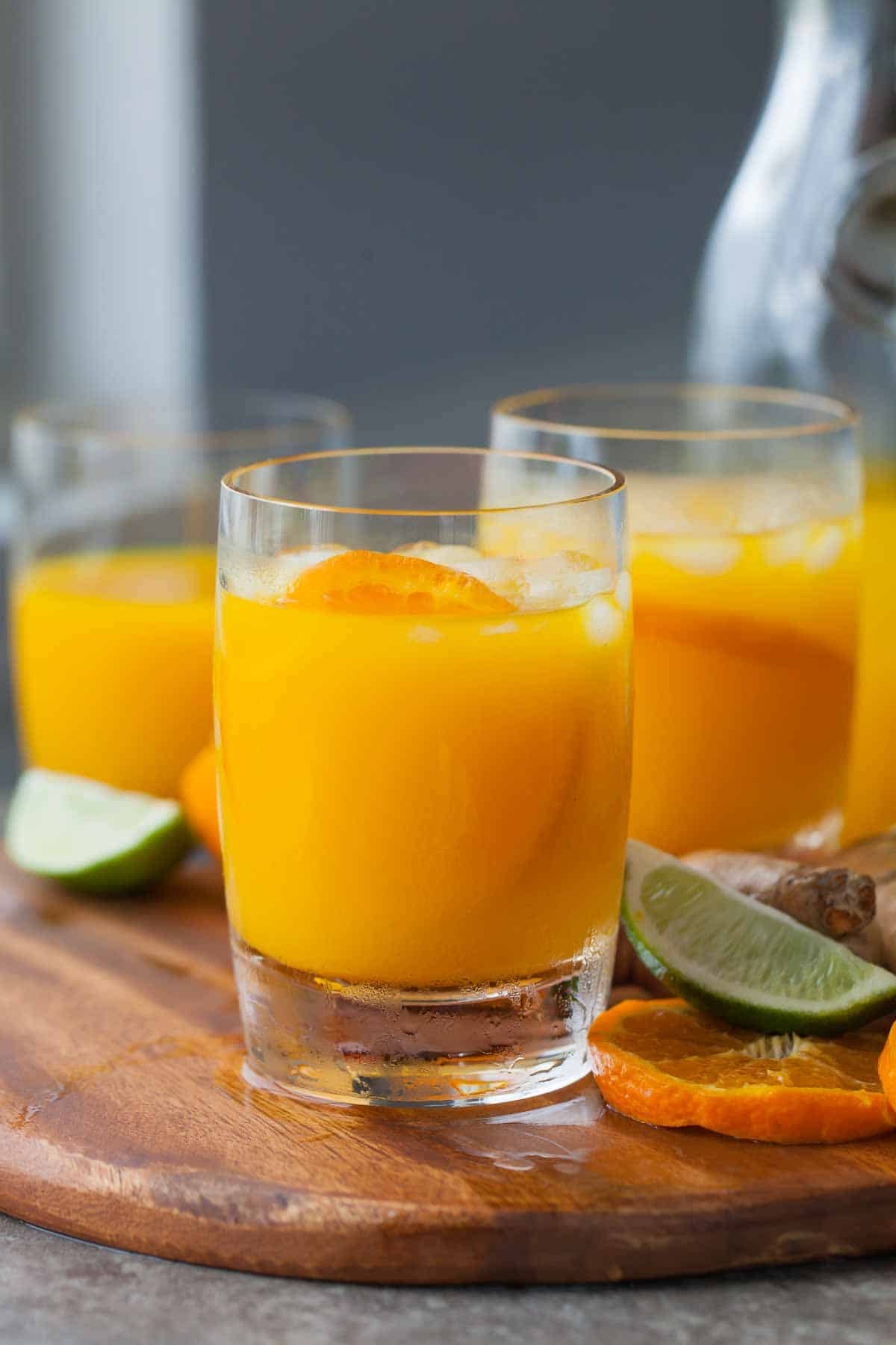 Turmeric Juice in Glass with Tangerine Wedge