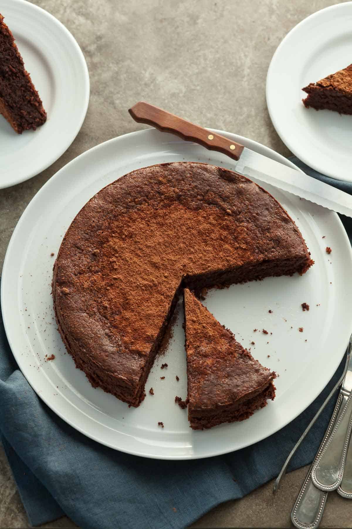 Flourless Chocolate Walnut Torte Sliced on Serving Plate with Knife