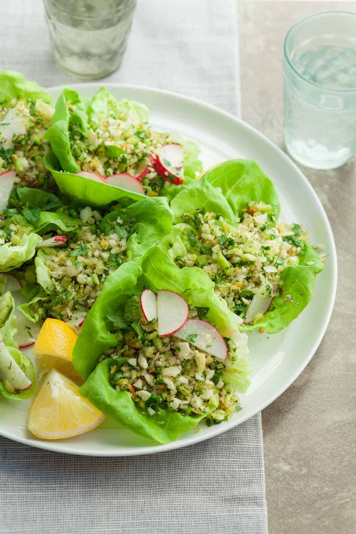 Broccoli Cauliflower Rice Salad on Plate with Lemon Wedges