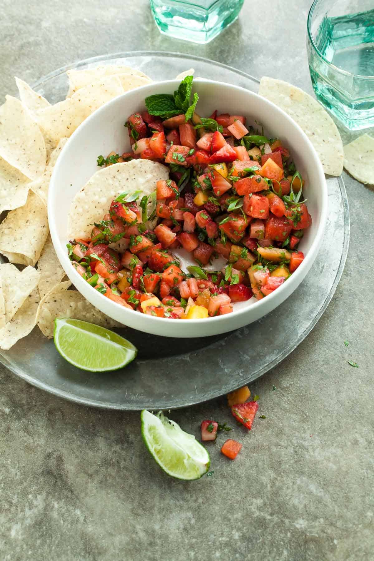 Strawberry Salsa in Bowl with Chips and Lime Wedges