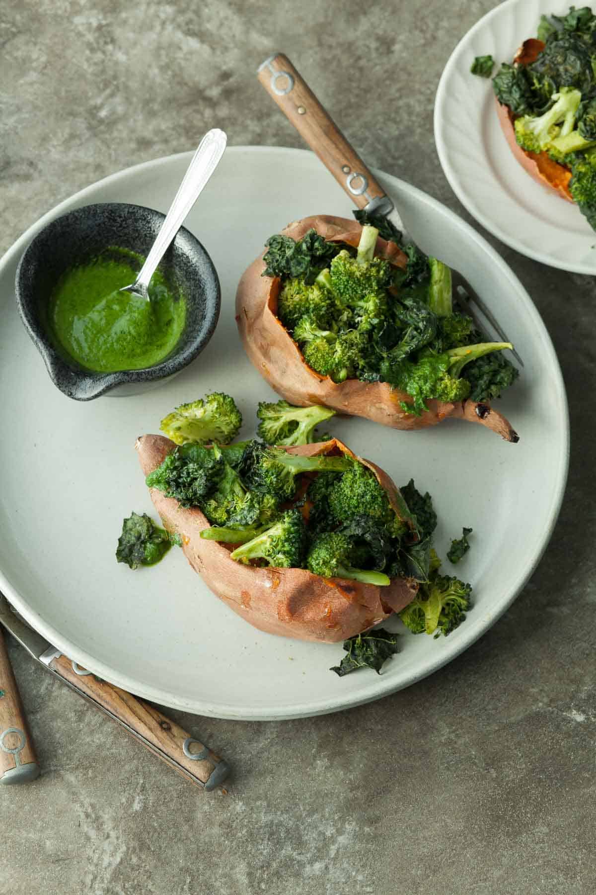 Vegan Stuffed Sweet Potatoes on Plate with Sauce in Bowl