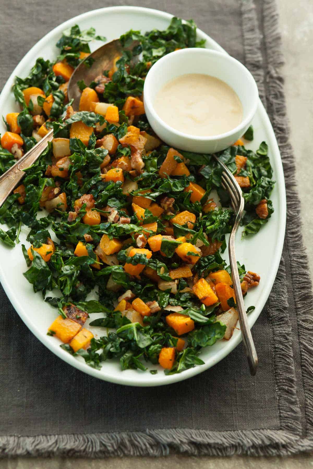 Kale and Butternut Squash Salad with Dressing and Serving Spoons