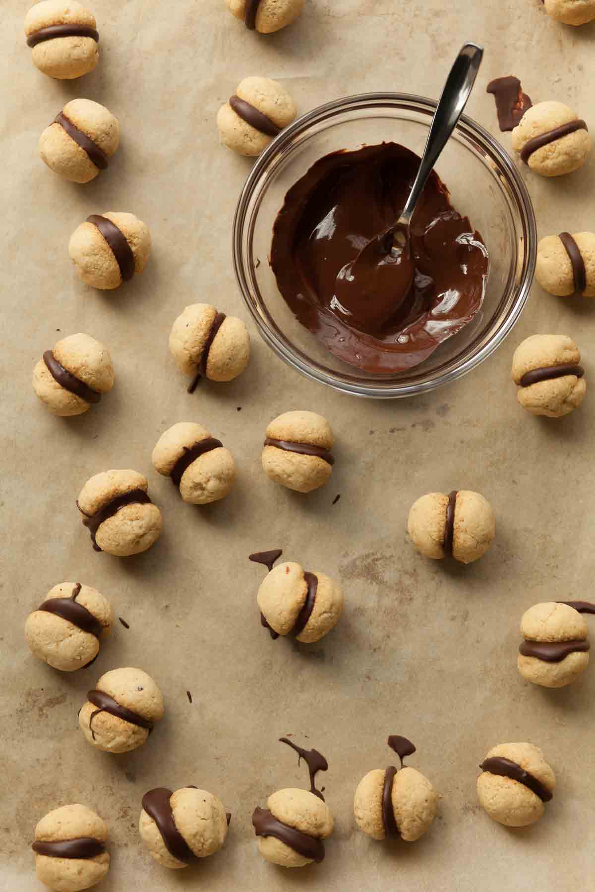 Baci Di Dama on Parchment with Bowl of Chocolate