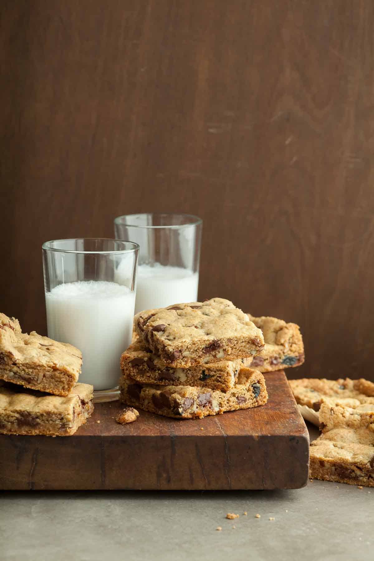 Vegan Blondies Stacked Next to Glass of Milk