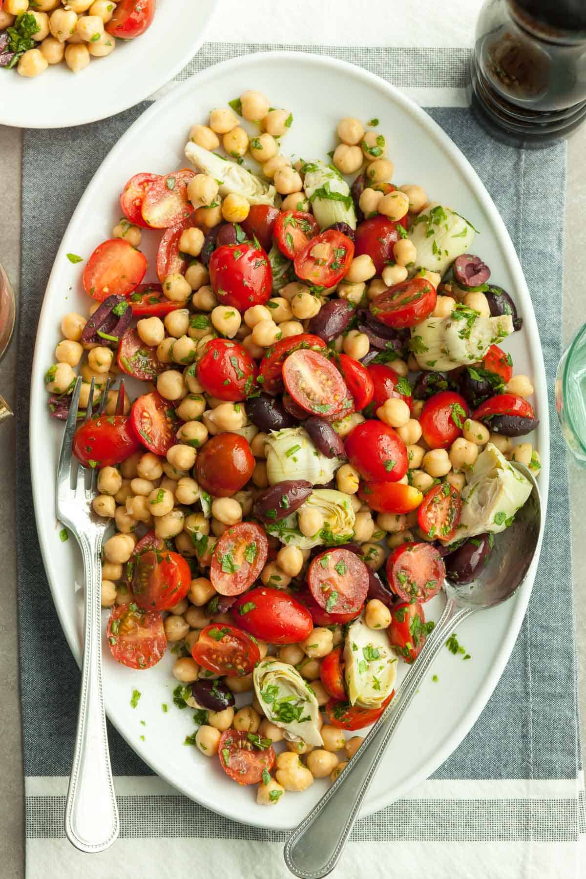 Tomato Chickpea Salad on plate with serving utensils