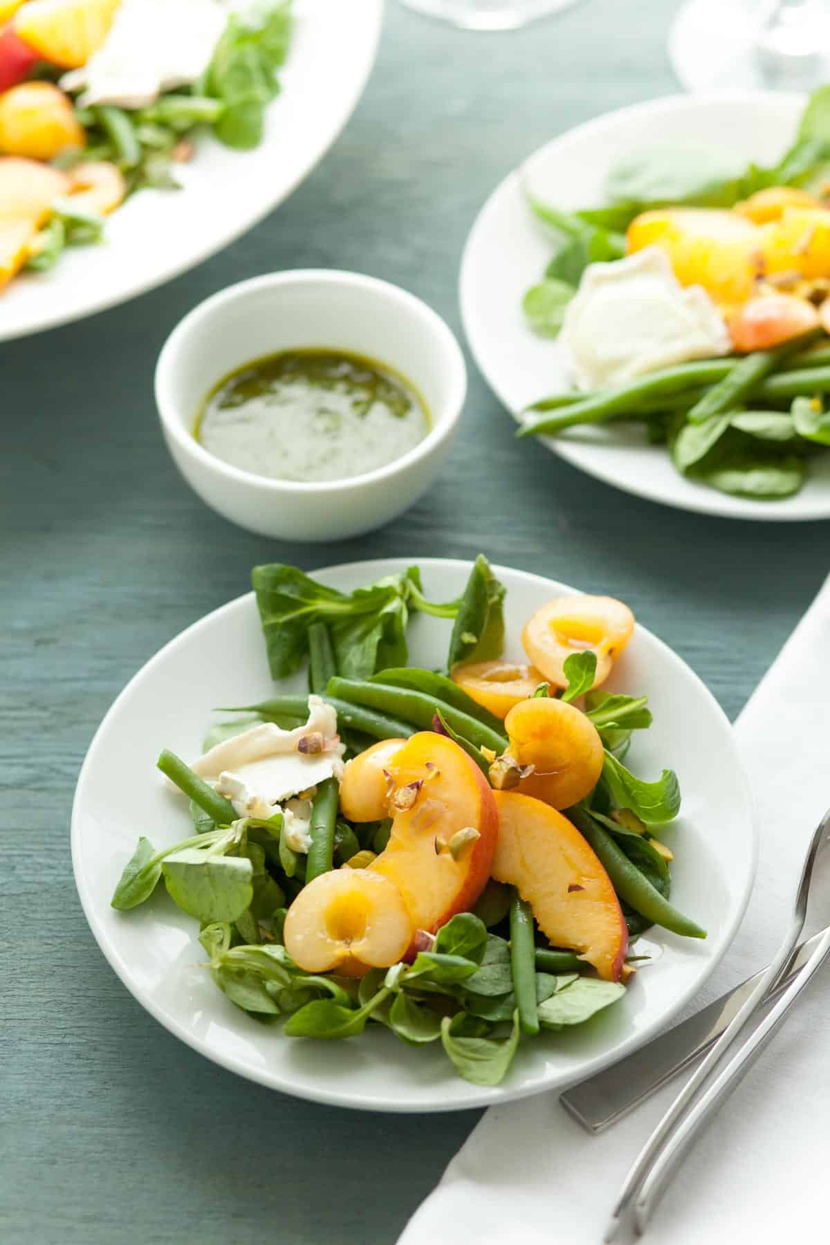 Peach Basil Salad on plates with dressing on side