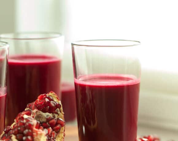 red juice in glass near pomegranate