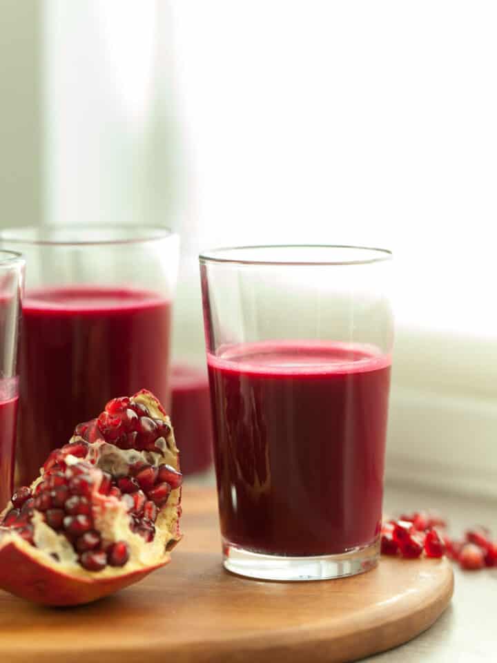 red juice in glass near pomegranate