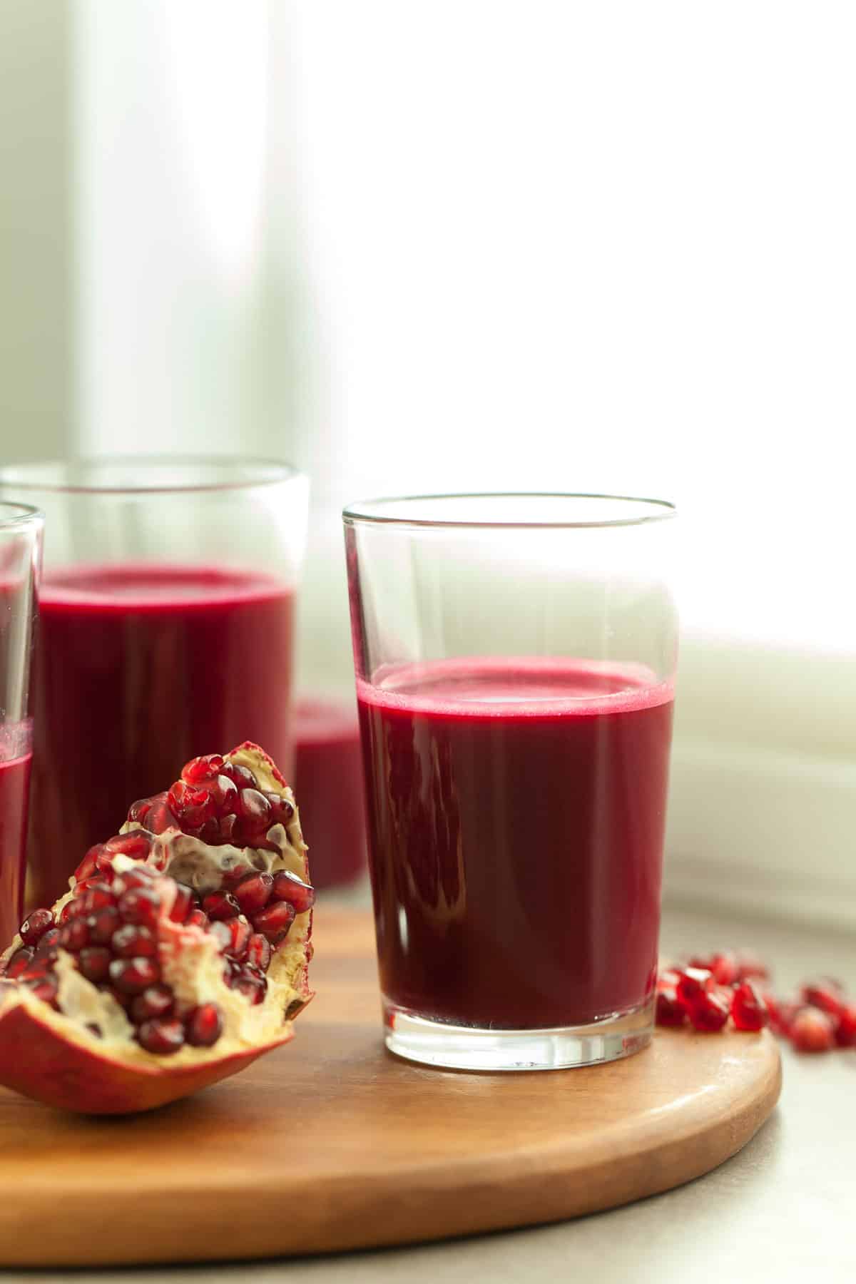 red juice in glass near pomegranate