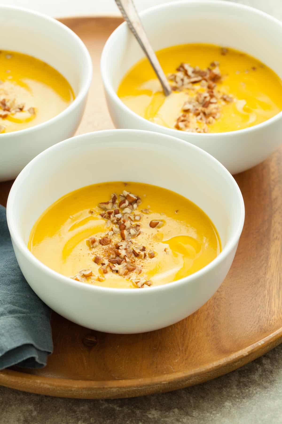 Sweet Potato and Carrot Soup in Bowl with Chopped Pecans