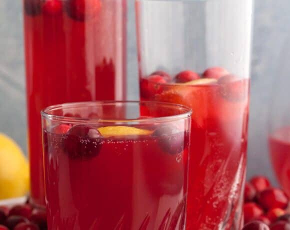 cranberry moctails in glasses on serving platter with fresh cranberries