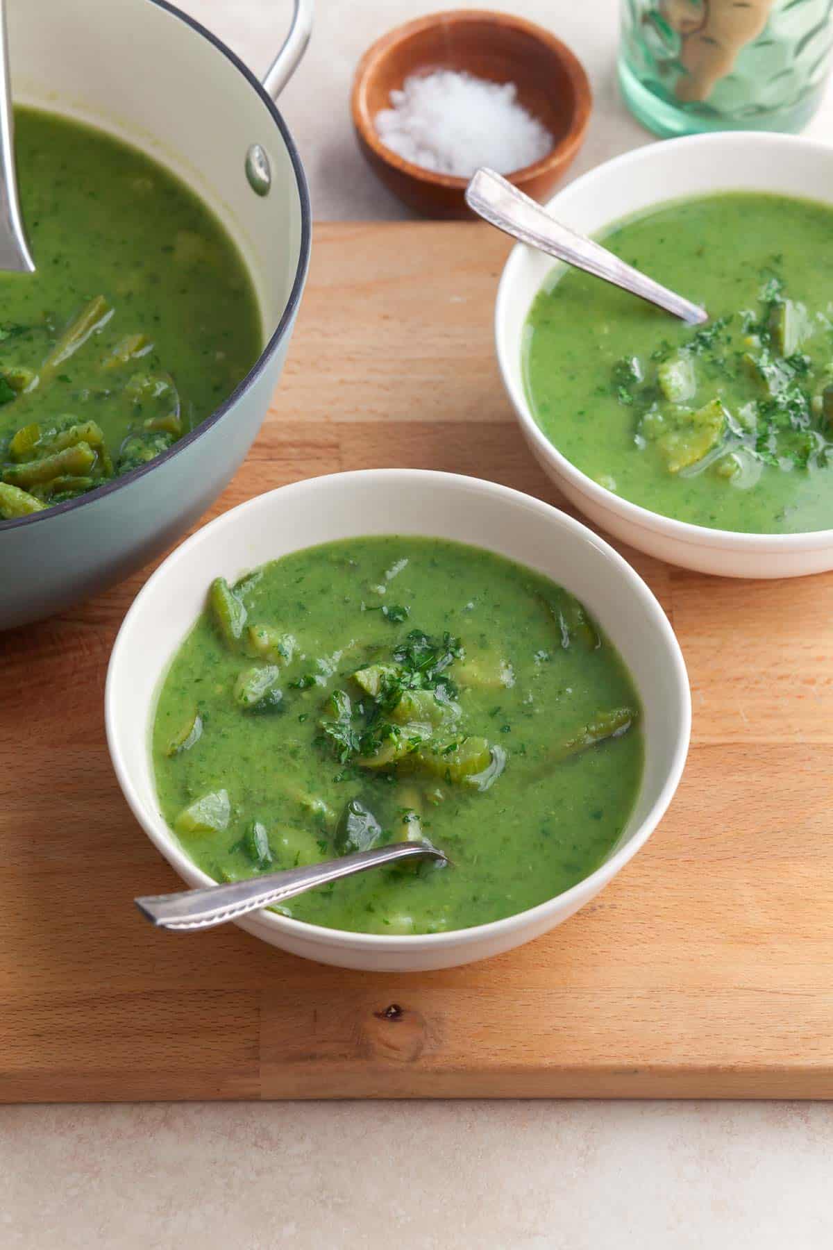 Green soup in bowls with chunks of vegetables