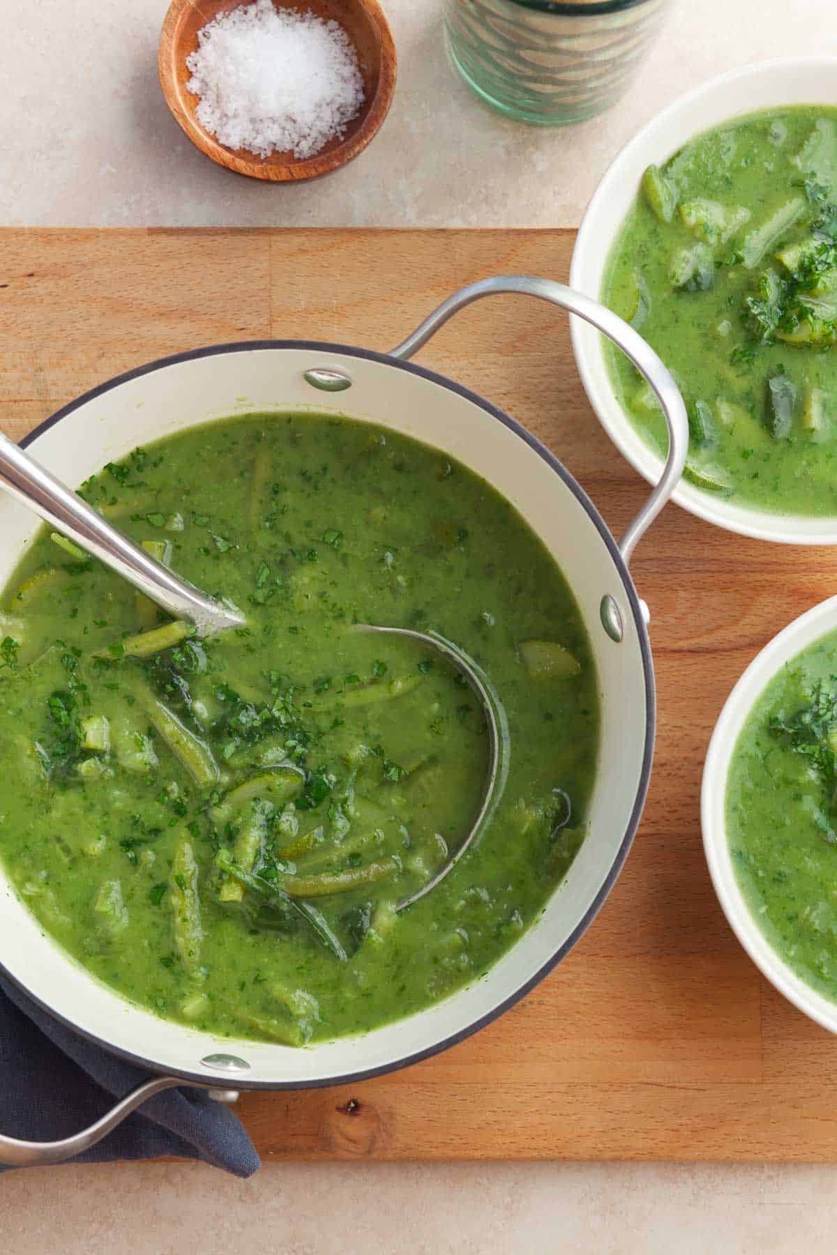 Green soup in soup pot with ladle