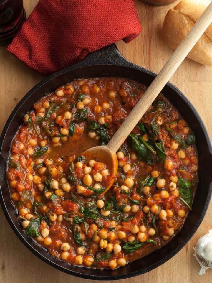 chickpea peas in tomato sauce in skillet with spinach