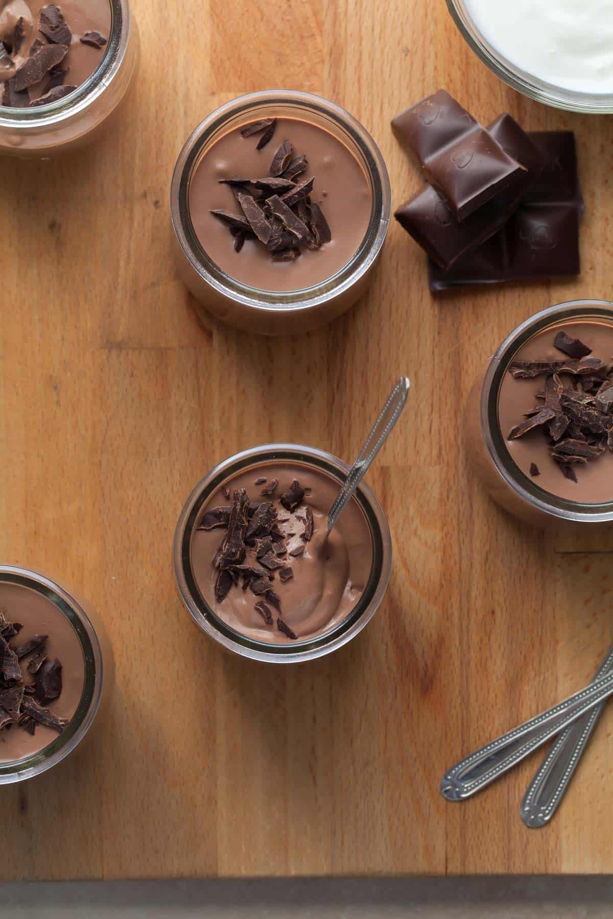 Chocolate Greek Yogurt in small pots with spoon.