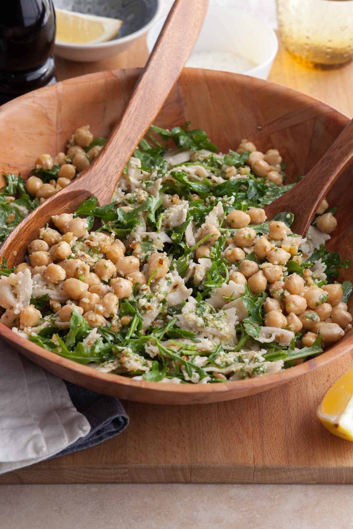 Fresh arugula pasta salad with chickpeas, pecorino, and a lemon dressing in serving bowl