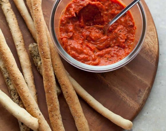 Crisp Italian breadsticks on board with tomato sauce