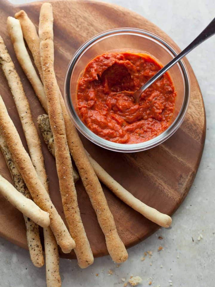 Crisp Italian breadsticks on board with tomato sauce