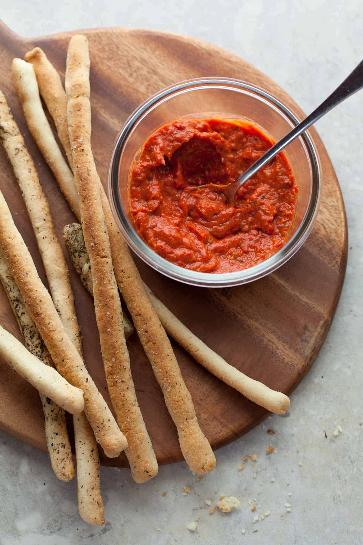 Crisp Italian breadsticks on board with tomato sauce