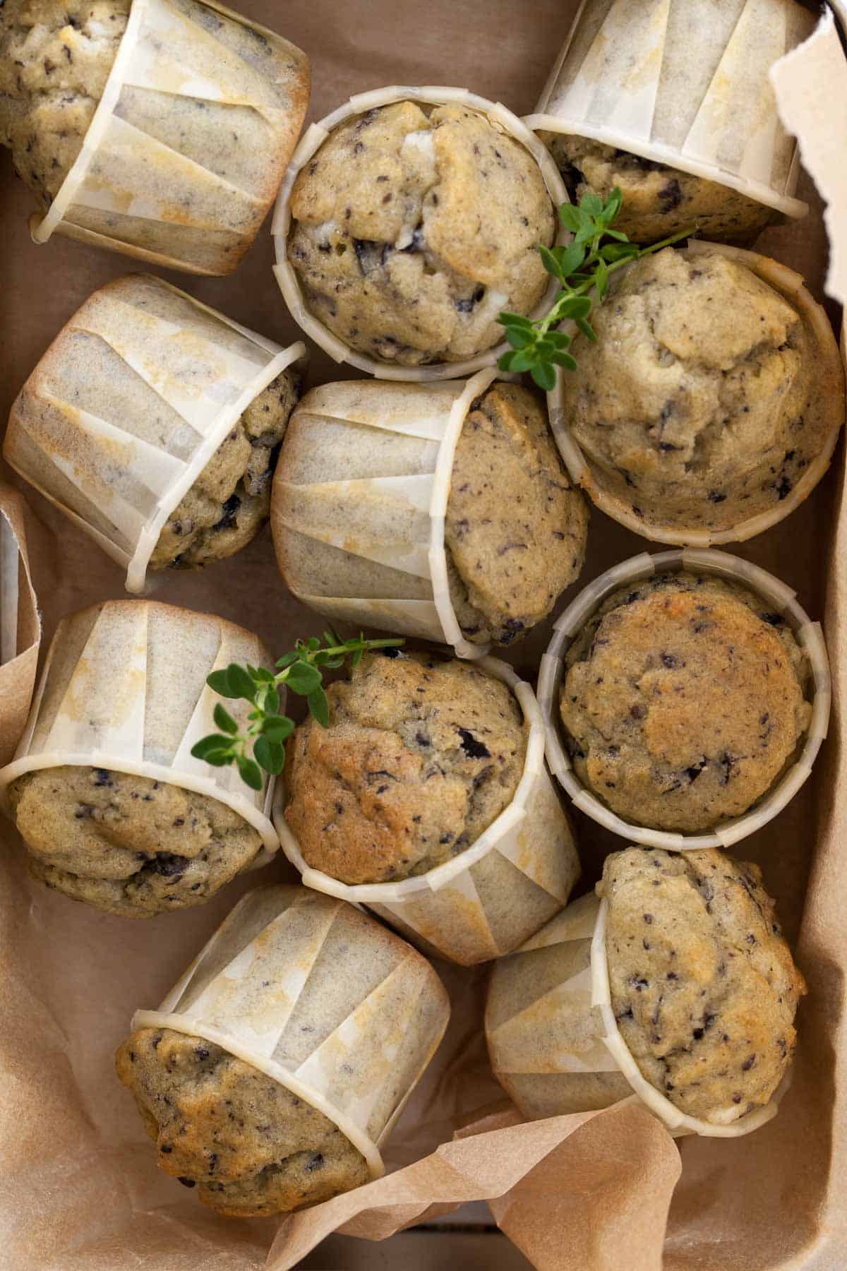 Savory gluten-free muffins made with feta, olives, and herbs in storage box.