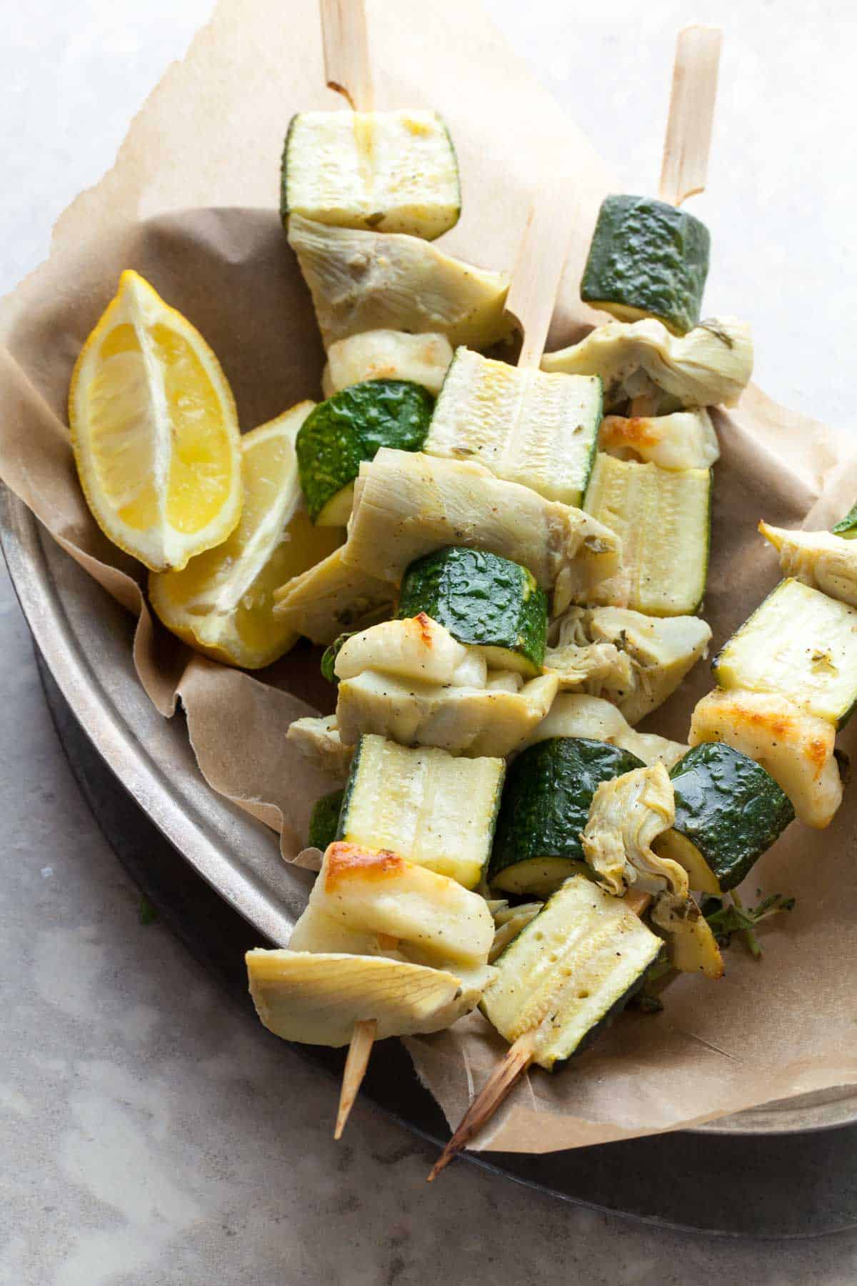 Grilled halloumi and vegetable skewers with lemon olive sauce in platter