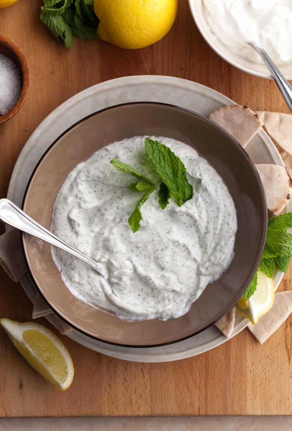 Top view of creamy yogurt mint sauce with fresh mint in bowl.