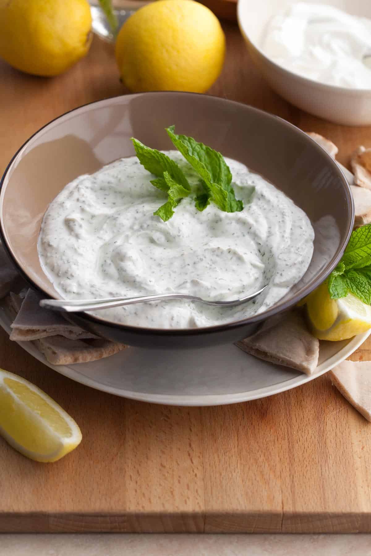 Yogurt and mint sauce in bowl served with pita.
