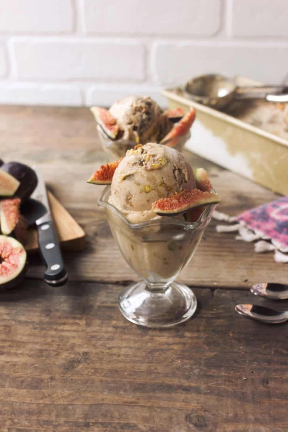 Fig ice cream with a coconut base and swirls of thick fig jam and toasted pistachios in serving cups