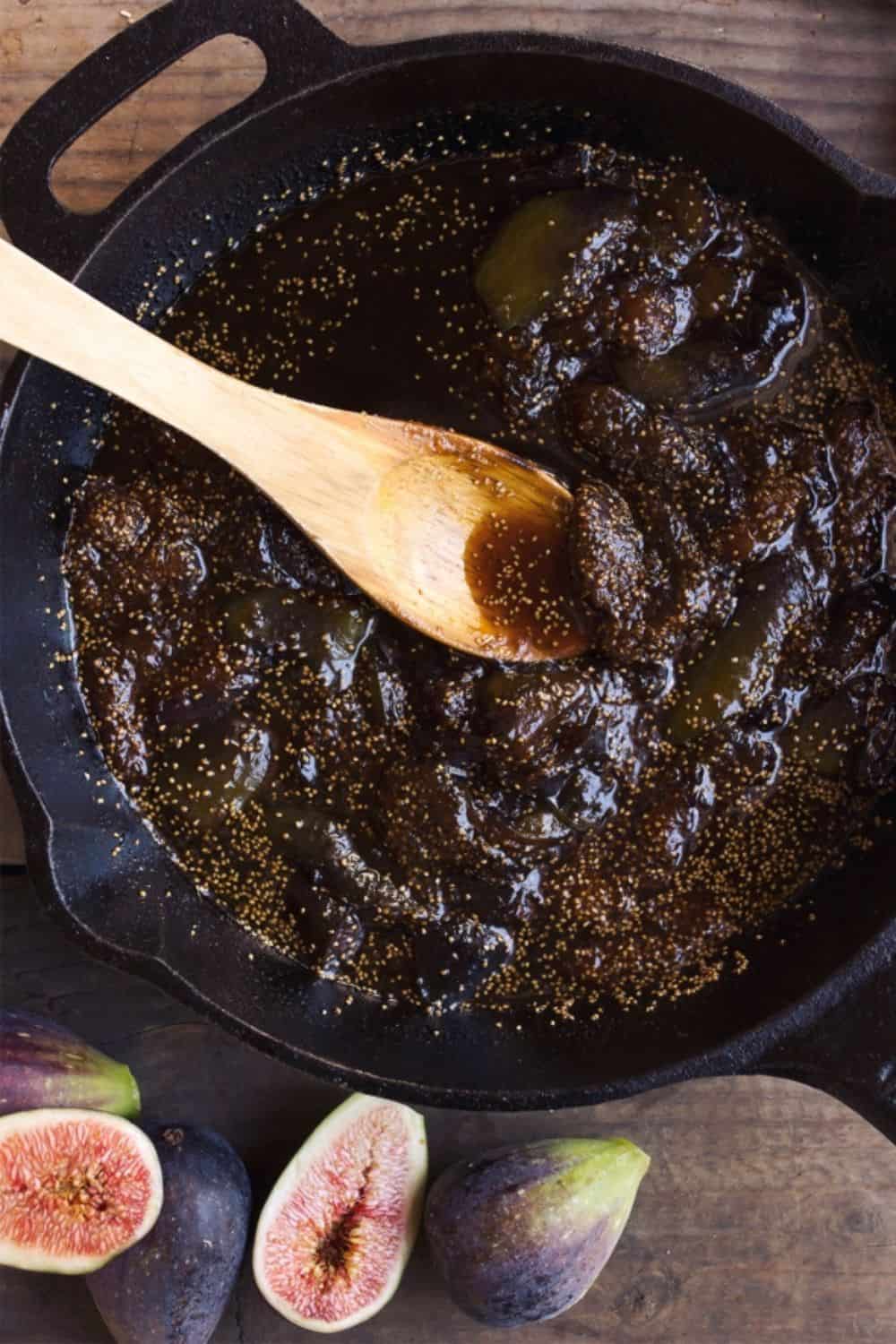 Cooked fig mixture simmering into a thick jam-like swirl in a saucepan
