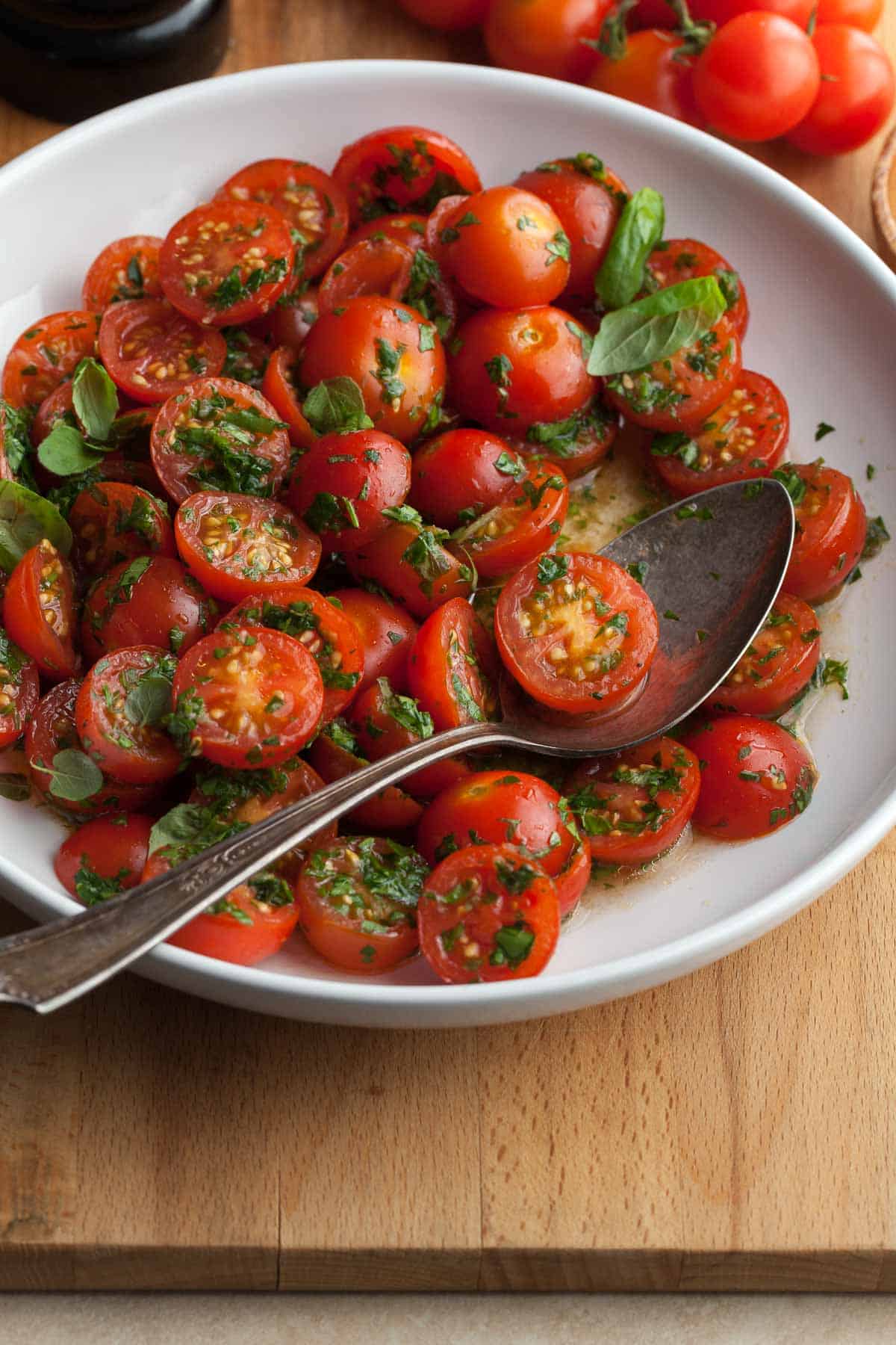 Make-Ahead Marinated Tomatoes with fresh herbs in bowl