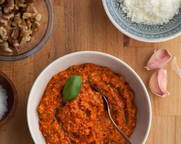 red pepper pesto made with jarred roasted peppers in a bowl topped with basil