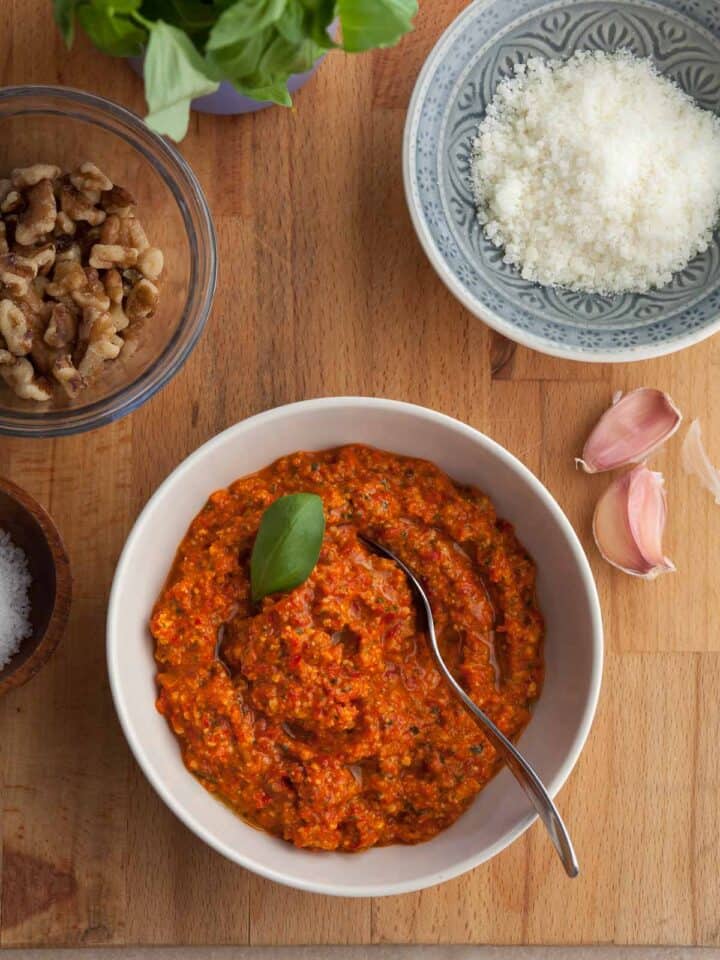 red pepper pesto made with jarred roasted peppers in a bowl topped with basil