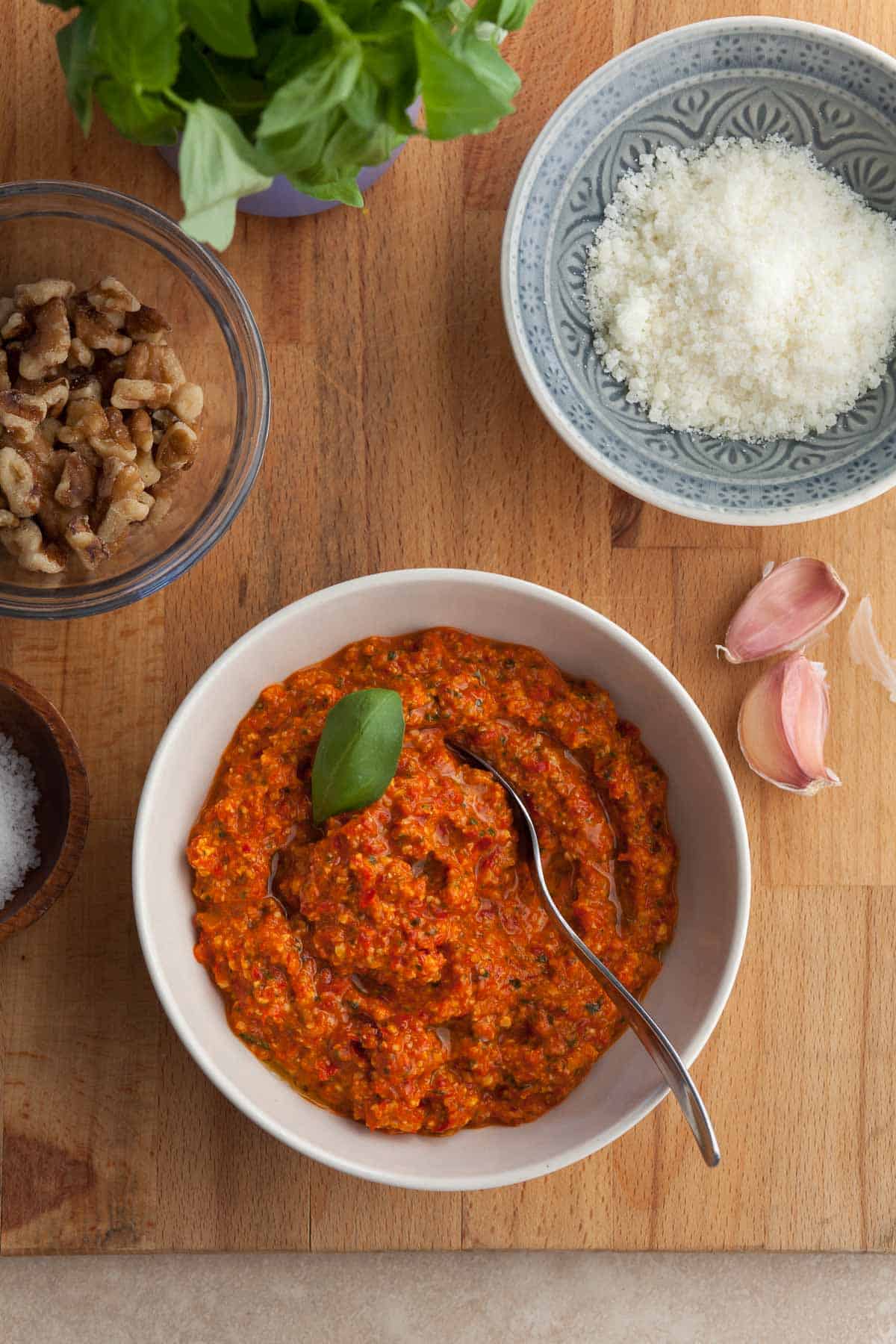 red pepper pesto made with jarred roasted peppers in a bowl topped with basil