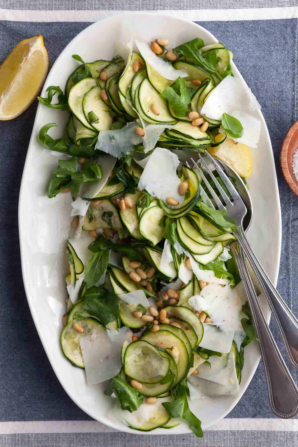 Zucchini Carpaccio (Easy Raw Zucchini Salad) on platter topped with pine nuts