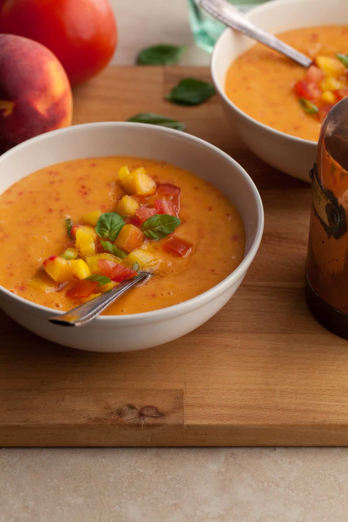 peach gazpacho soup made with tomatoes and fresh basil in bowls