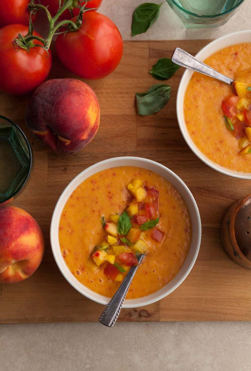 chilled peach tomato soup with fresh basil served in bowls
