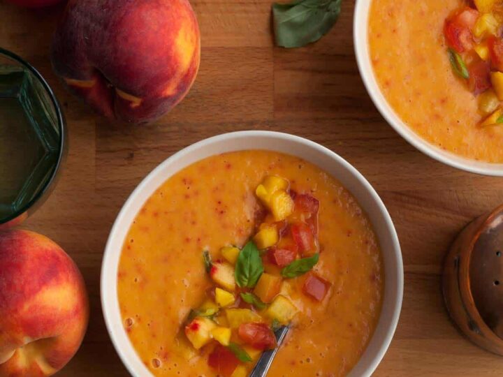 chilled peach tomato soup with fresh basil served in bowls