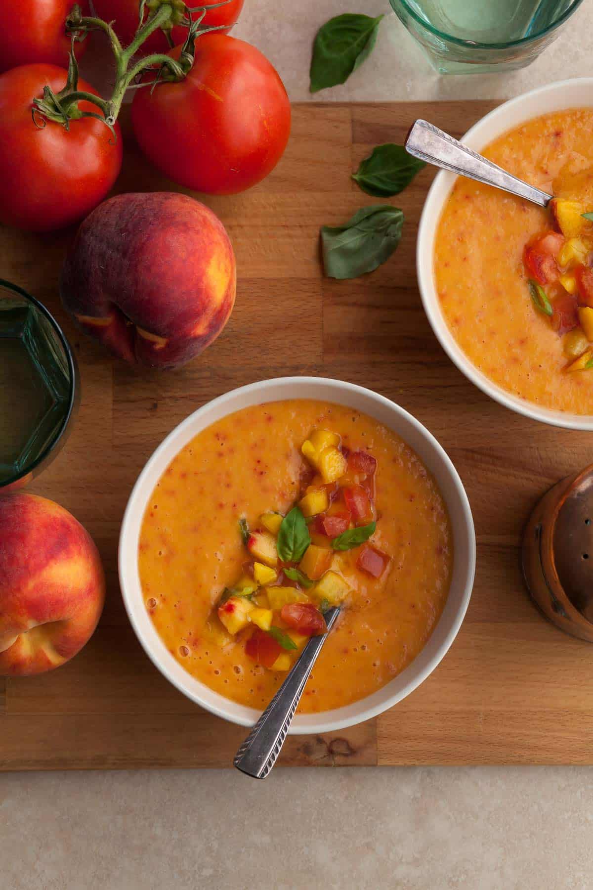 chilled peach tomato soup with fresh basil served in bowls