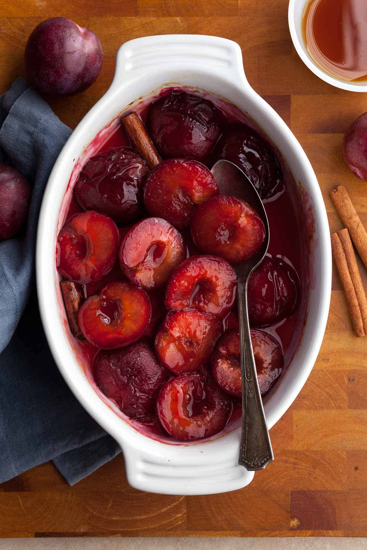 roasted plums with maple syrup and cinnamon in dish