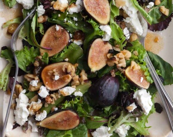 Fig and goat cheese salad with balsamic dressing, walnuts and cherries on serving platter